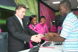 Zain Africa CEO Mr Chris Gabriel selling a sim card to a new Zain Ghana customer at the flagship store in Osu on Oxford Street in Accra on the day the 3.5G network was launched.