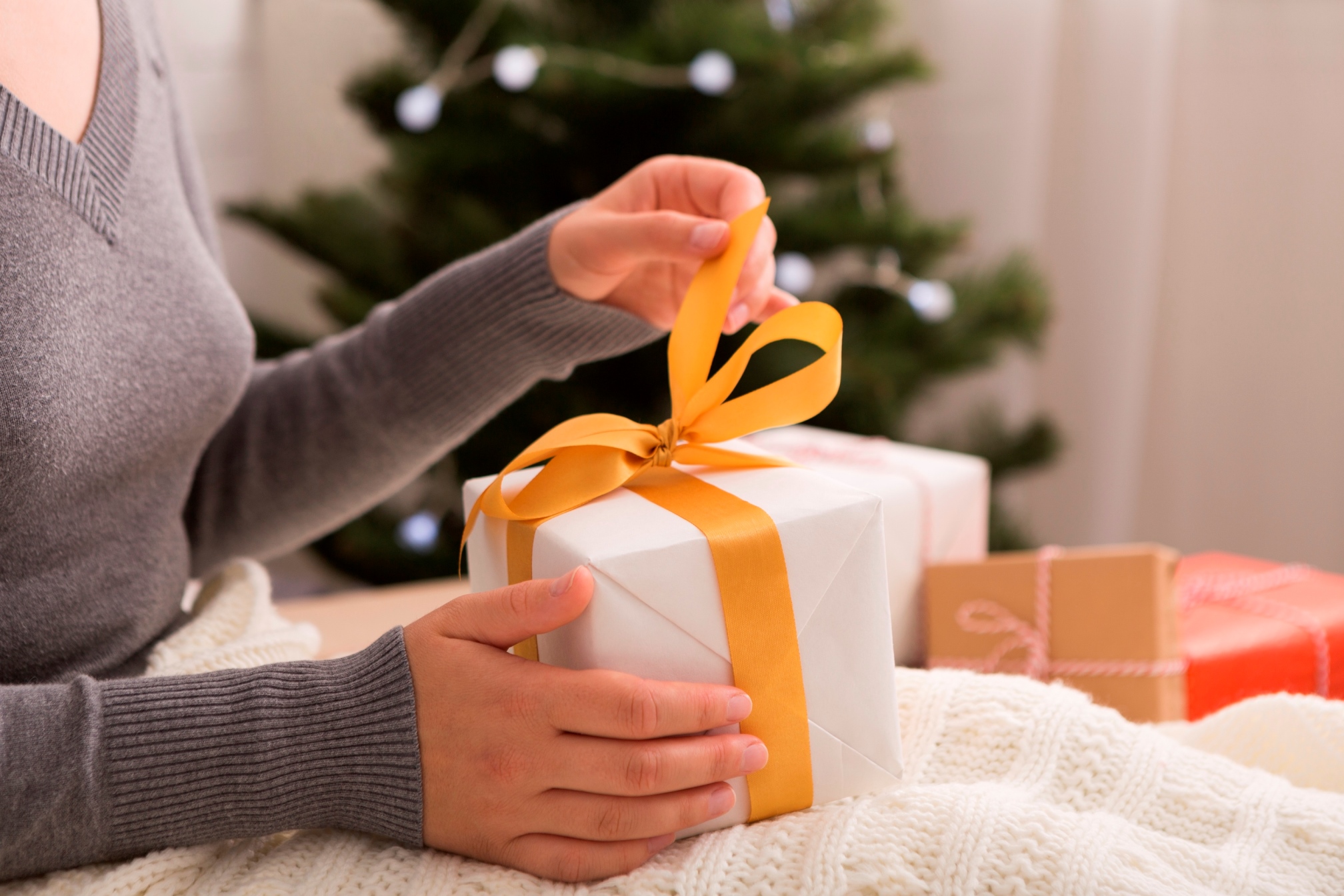 Unpacking presents. Woman opening gift box on Christmas background