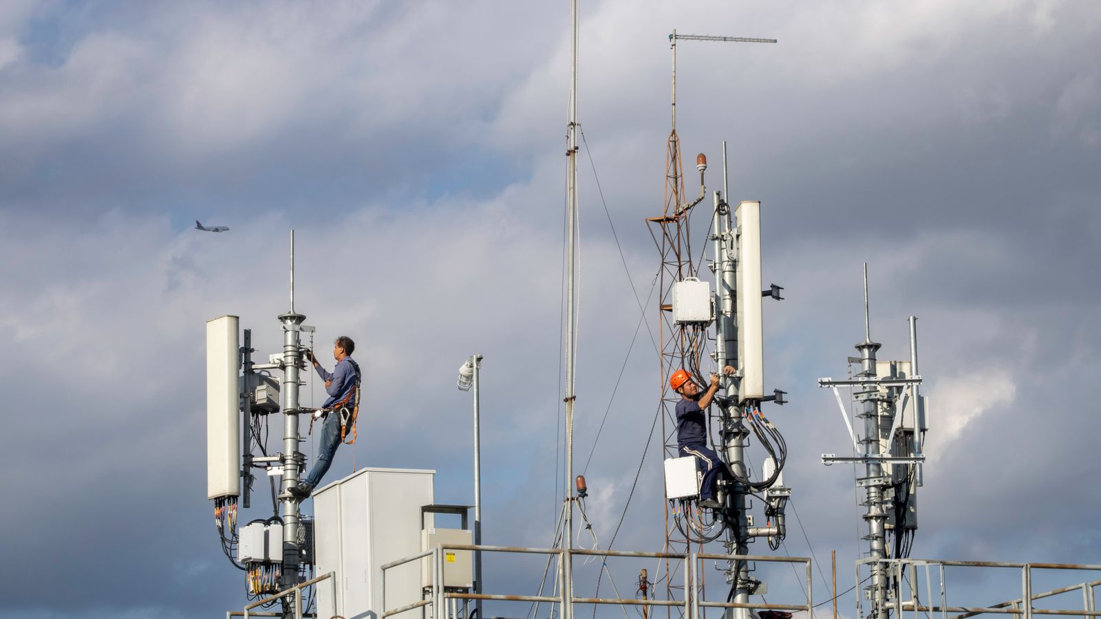Two technicians working on a cellular telecoms tower