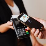 A customer paying by smartphone at a retail counter