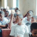 Students in school uniforms paying attention in a classroom