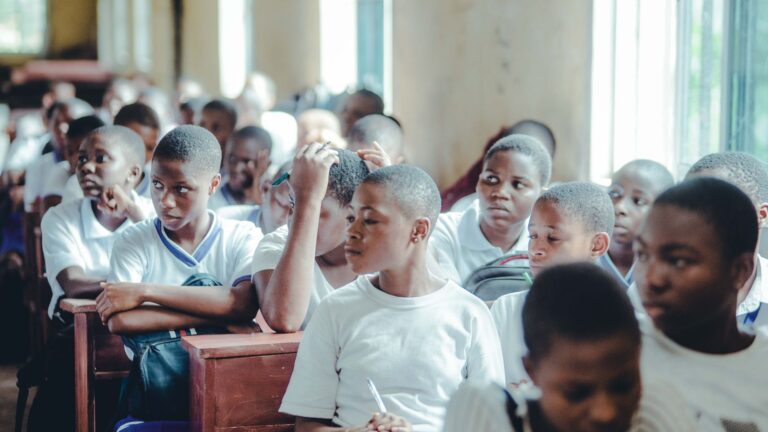 Students in school uniforms paying attention in a classroom