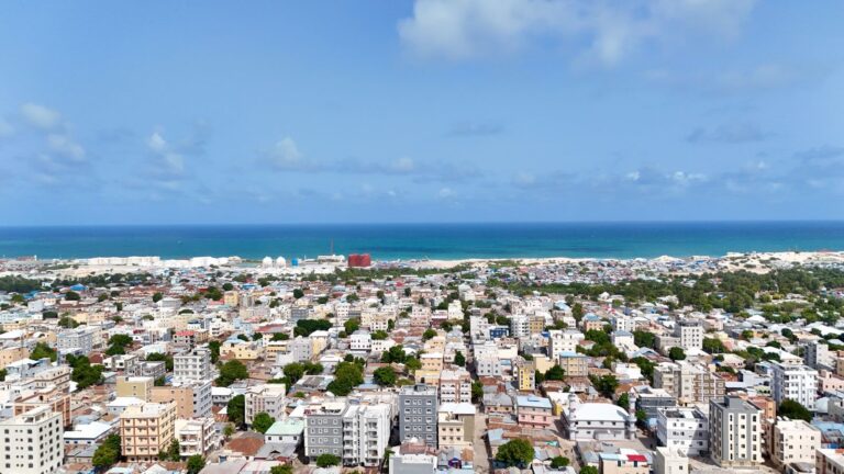 Aerial view of Mogadishu, Somalia, with rows of buildings and the Indian Ocean behind them