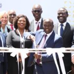 Officials cut a ribbon marked NBO2 at the opening of Digital Realty's second Nairobi data centre, with Digital Realty branding behind them