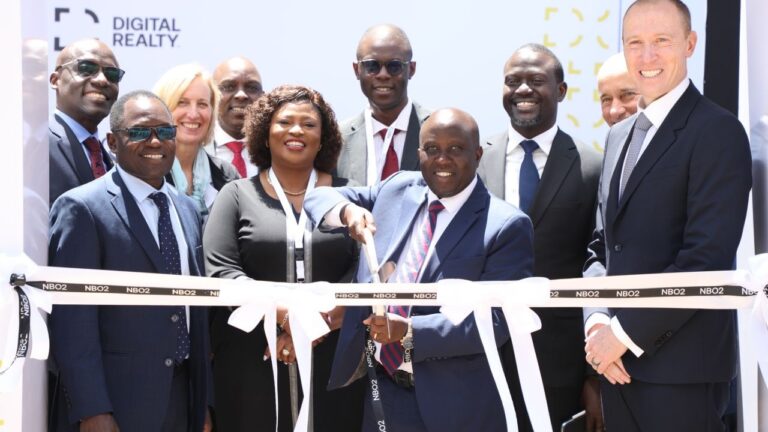 Officials cut a ribbon marked NBO2 at the opening of Digital Realty s second Nairobi data centre, with Digital Realty branding behind them