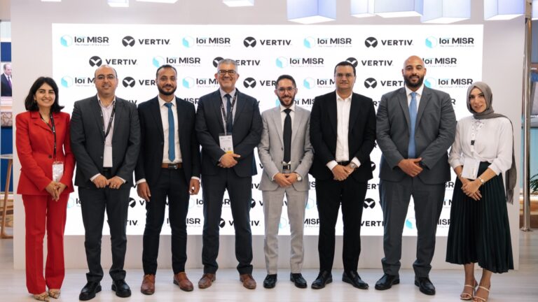 Eight representatives of Vertiv and IoT Misr stand in front of a backdrop showing both company logos