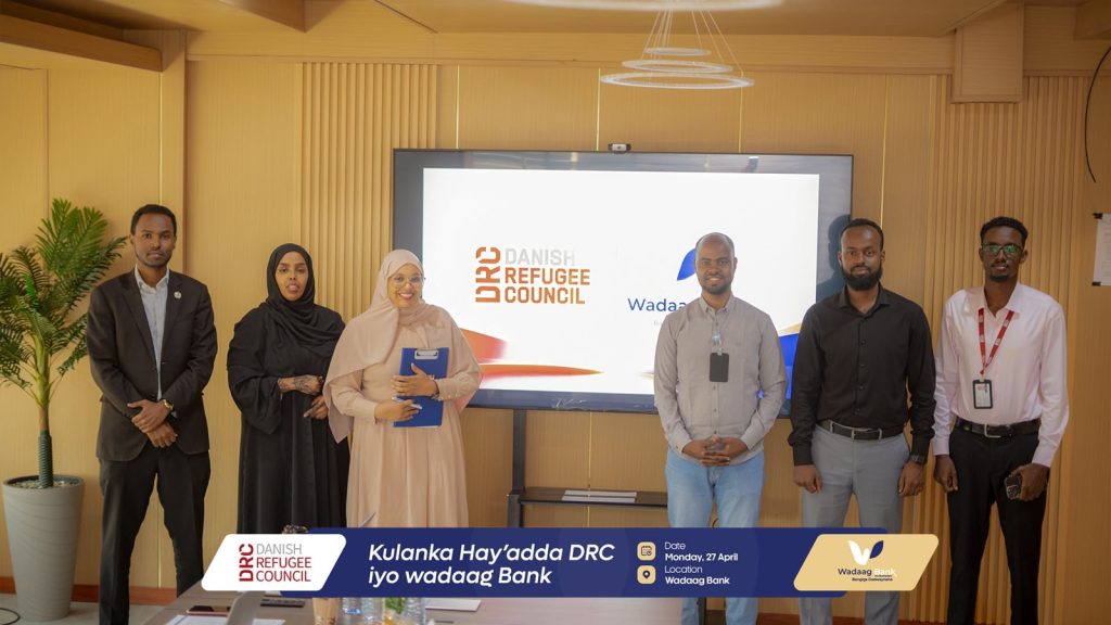 Q&A: building a digital Islamic bank in Somaliland 13 Wadaag Bank staff and Danish Refugee Council representatives stand before a joint presentation slide at the bank's Hargeisa office.